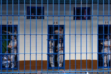 Inmates stand at the doors to their cells at the Ilopango women’s prison
