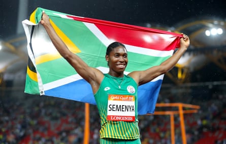 Caster Semenya in running clothes holds up a South African flag