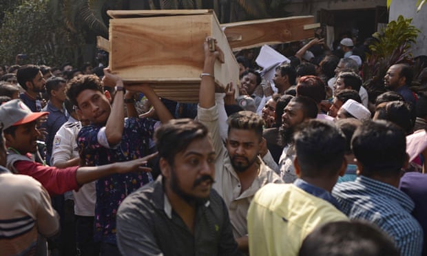 Bangladeshis carry coffins of relatives out from a morgue after the fire in Dhaka.
