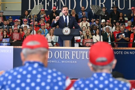 JD Vance gestures with a clenched fist while speaking at a rally podium before a crowd