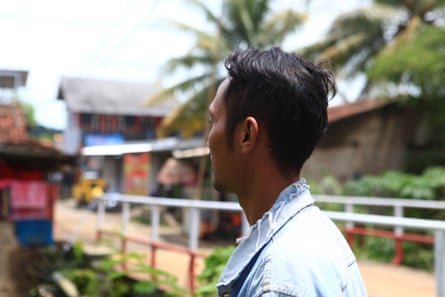 A man in a denim jacket with his face turned away