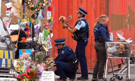 Police place tributes on a memorial wall as police lines are relaxed around the Linwood Mosque in Christchurch.