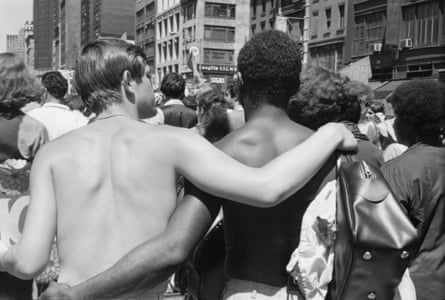 Back view of pair of shirtless men as they walk, arm in arm, during the first Stonewall anniversary march, then known as Gay Liberation Day (and later Gay Pride Day), New York, New York, June 28, 1970.