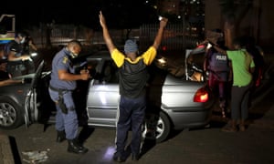 Police officers search people on New Year’s Eve in Johannesburg, South Africa. Police have been more stringent in enforcing restrictions since a partial lockdown was reinstated last month.
