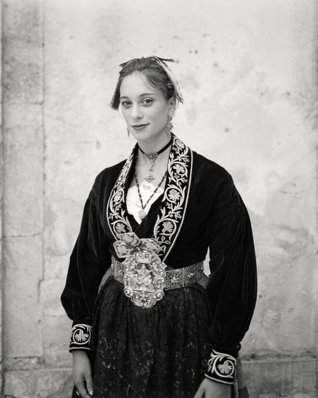 Woman wearing a traditional Sicilian black dress with white embroidery