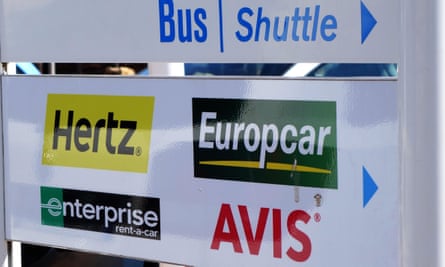A sign showing the way to car hire companies at an airport.