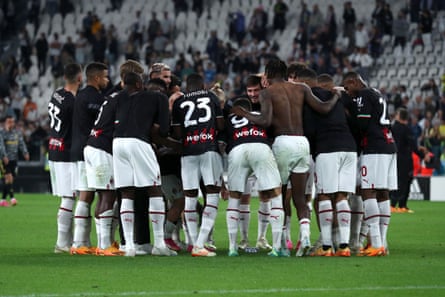 Milan players huddle on the pitch after their victory against Juventus.