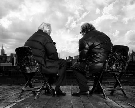 Two men look out sat on a rooftop in a black and white image