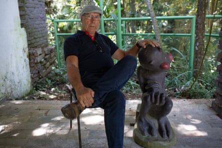 Marco Antônio Reis sits next to a statue of the alien locals apparently saw in Varginha in 1996