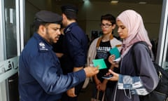 A guard checks the passport of a Palestinian women  at the Rafah border crossing with Egypt