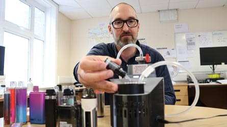 A man in a laboratory with several colourful tubes in front of him