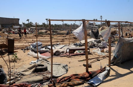People stare at makeshift tents and other structures left destroyed