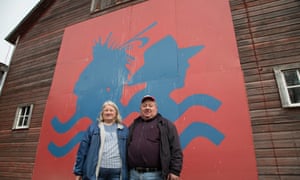 Art and Helen Tanderup stand by a large Cowboys and Indians alliance sign on their corn farm outside of Neligh, Nebraska.
