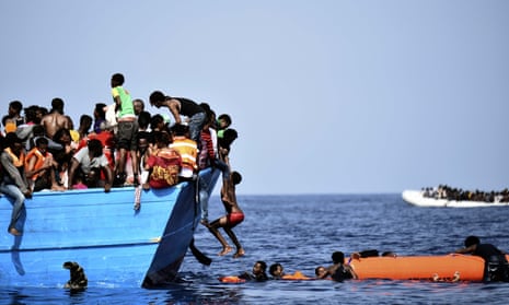 Migrants wait to be rescued as they drift in the Mediterranean, some 12 miles north of Libya.