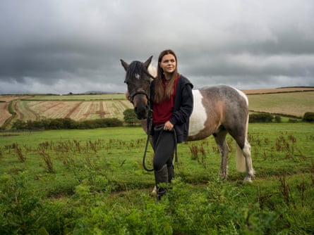A young woman and a horse in a field