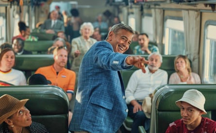 George Clooney in a train carriage with passengers in Jay Kelly