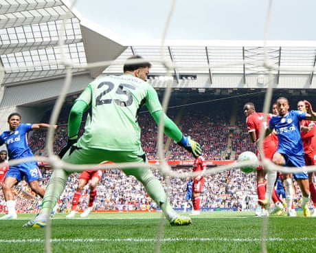 Goalkeeper Giorgi Mamardashvili in green prepares to defend as players contest the ball near the goal.