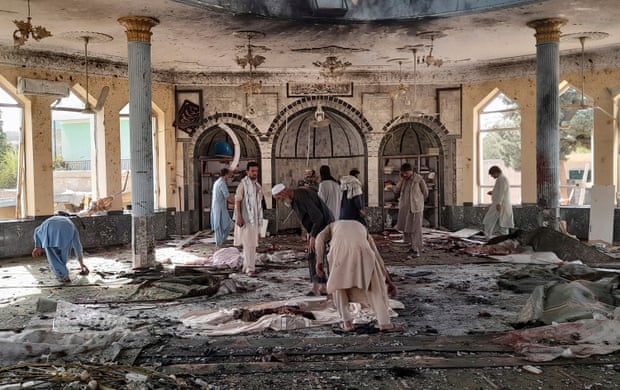 People pick through debris in a mosque damaged by bombing in Kunduz, northern Afghanistan