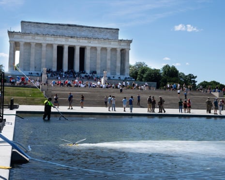 Hydrogen peroxide is pumped into the newly renovated pool to clean algae as residents and tourists walk by on Saturday.