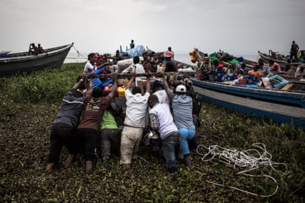 Internally displaced people push out a boat in Tchomia