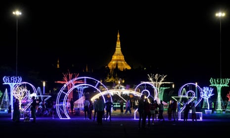 People gather to take part in New Year celebrations at a public park in Yangon, where it is shortly after 9pm at the time of posting
