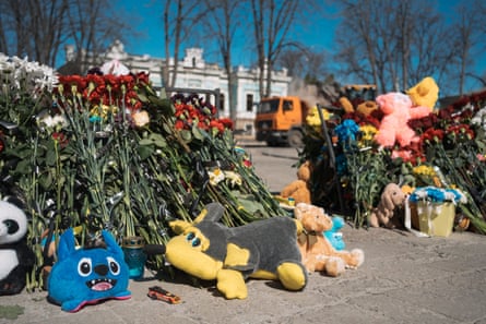 People lay flowers at the site of the rocket strike.