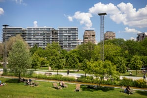people sitting on grass with buildings in background
