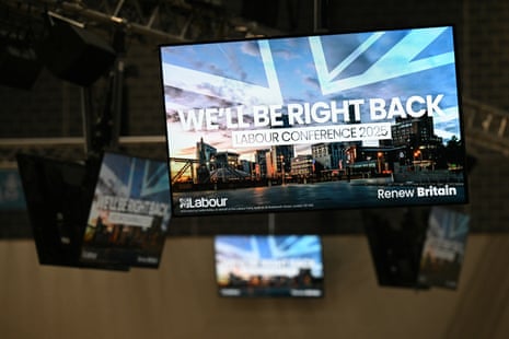Screens hang above the floorspace inside the exhibition centre, the venue for the annual Labour party conference in Liverpool, on Saturday.