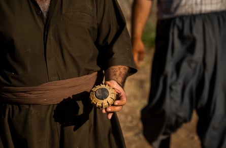 Rizgar Ali holds a landmine he removed from a villager’s property after the villager waved down Ali’s brother, landmine deminer Hoshyar Ali, who drove past the man’s house at Serdera Village near Penjwen, Iraqi Kurdistan