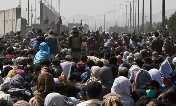 Afghans  hoping to flee the country gather near Kabul airport in August this year.
