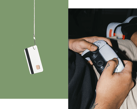 Credit card hanging on hook; hands holding gaming controller