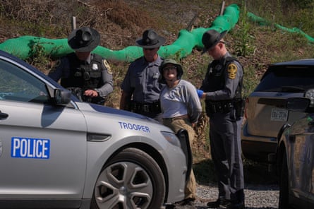 three police officers arrest a protester outside