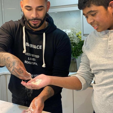 Sandro helps a young person to improve his skills in the kitchen.
