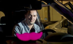Lyft co-founder John Zimmer displays his company's 'glowstache' at an event in San Francisco.