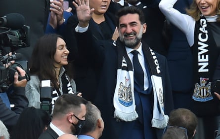 Yasir al-Rumayyan with a NUFC scarf around his shoulders waving to cameras from the stands