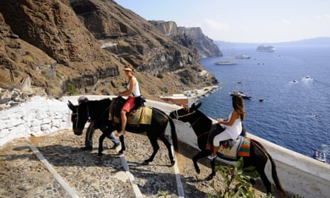 Tourists riding donkeys in Santorini