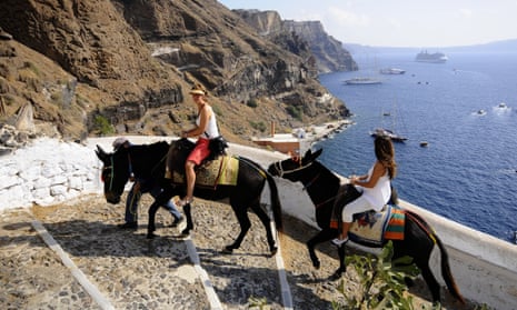Tourists riding donkeys in Fira, island of Santorini.