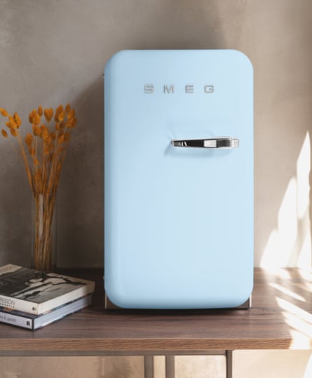 A pale blue, mini Smeg fridge on a bedside table.