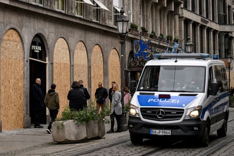 A police van parked outside a boarded up Prada shop.