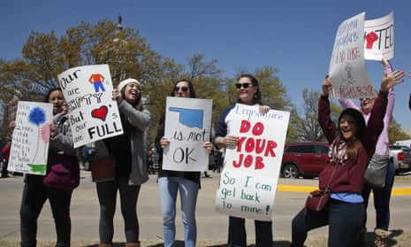 Teachers from Apollo elementary school in the Putnam City school district of Oklahoma City, wave signs at passing cars outside the state capitol as protests over school funding continue on Wednesday.
