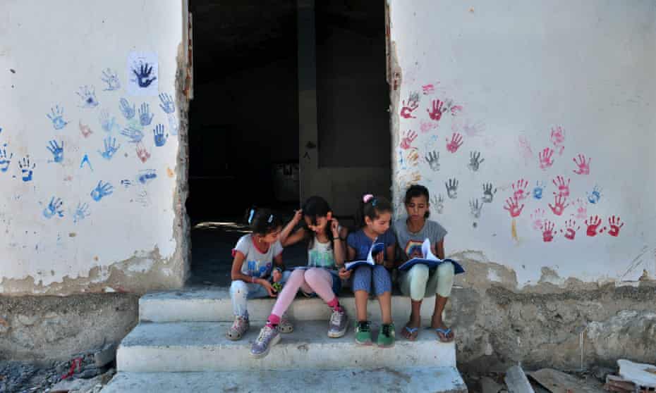 Children sit on stairs in the refugee camp of Lagadikia, Greece.