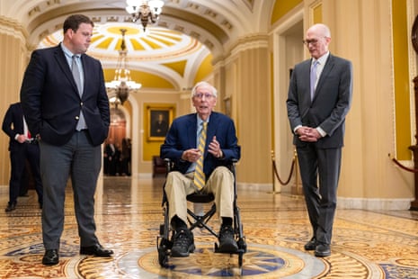 three men with the center one in a wheelchair