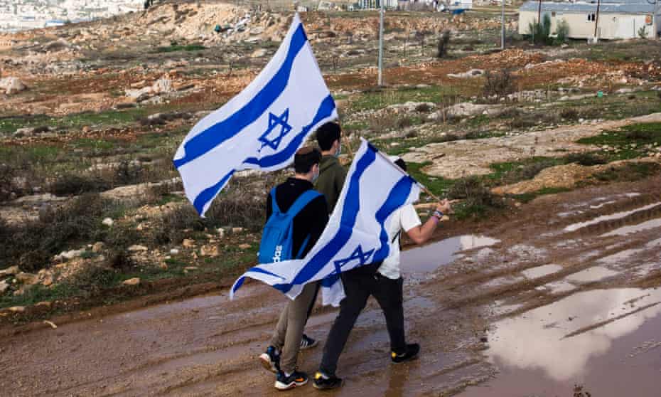 Israeli youths hold the Israeli flag as they are walking on Givat Hamatos on November 16, 2020 in Jerusalem, Israel. 