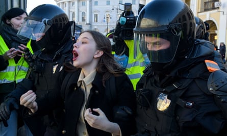 Police officers detain a woman during an anti-war protest in St Petersburg on 13 March.