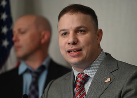 A middle-aged man in a suit speaks