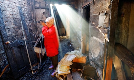 Local resident Svetlana reacts inside her neighbour Anatoly's burnt house, which was destroyed in recent shelling in the settlement of Olenivka near Donetsk.
