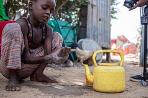 Ahmed Ali uses ash and soil to wash his hands outside his makeshift home at Xidig IDP camp in Mogadishu.