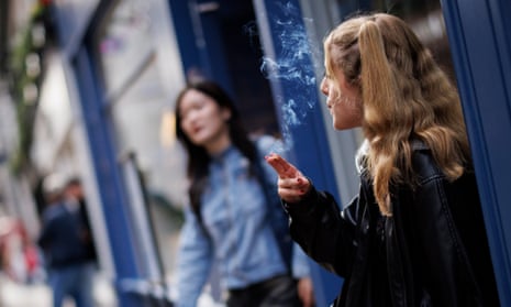 A young woman smokes in London, Britain.