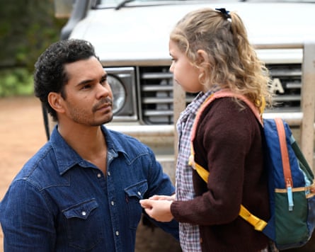Man kneels down beside girl