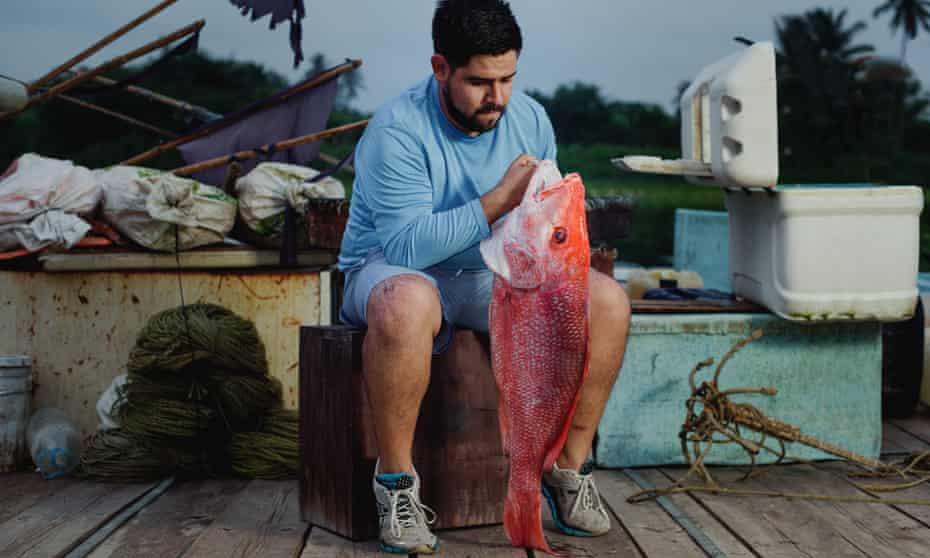 Chef Erik Guerrero holding a fish killed by ike jime